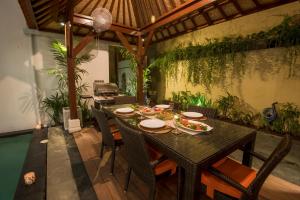 a dining room with a table with food on it at Villa Rendezvous Bali in Seminyak