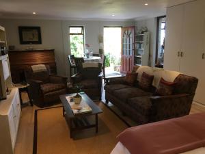 a living room with couches and a coffee table at Geranium Studio in Somerset West