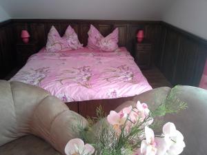 a bedroom with a pink bed with pink sheets and flowers at Vila Patricie in Luhačovice