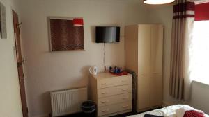 een slaapkamer met een dressoir en een televisie aan de muur bij The Middleton in Blackpool