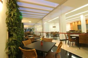 a dining room with a table and chairs and tables and tablesktop at Tupyguá Brasil Hotel in Pedro Leopoldo