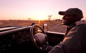 un hombre conduciendo un coche en el desierto en Nambiti Hills Private Game Experience, en Nambiti Game Reserve