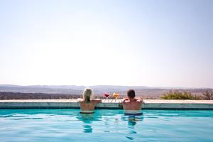 een man en vrouw zittend in een zwembad bij Nambiti Hills Private Game Experience in wildreservaat Nambiti