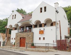 uma grande casa branca com uma porta vermelha em Penzión Kállai a Vináreň em Fiľakovo