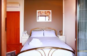モンツァンバーノにあるB&b Campovoloのベッドルーム1室(木製ヘッドボード付きのベッド1台付)