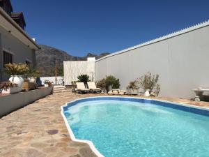 a swimming pool in a yard next to a building at Studio pool room in Hout Bay +8 photos