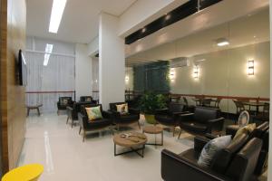 a waiting room with couches and chairs and tables at Tupyguá Brasil Hotel in Pedro Leopoldo