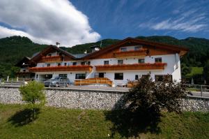 a house with a car parked in front of it at Hotel Al Sole in Tarvisio