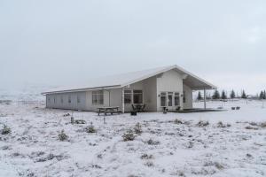 un edificio en un campo con nieve en el suelo en Álftröð Guesthouse, en Brautarholt