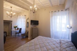 ヴィテルボにあるLa Rocca Suiteのベッドルーム(ベッド1台、テーブル、テレビ付)