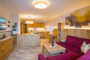 Haus Sonnleit في كوسن: غرفة معيشة مع أريكة حمراء ومطبخ