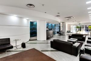 a lobby with black leather chairs and a bar at Mediterraneo Palace Hotel in Ragusa