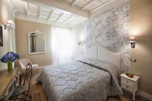 1 dormitorio con cama, mesa y espejo en La Rocca Suite, en Viterbo