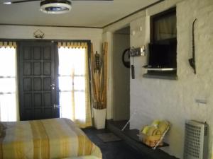 1 dormitorio con 1 cama y TV en la pared en Lo De Rossi Tandil-Dpto.1 Amb-Alquiler Temporario en Tandil