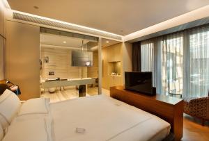 a bedroom with a bed and a television and a bathroom at Fer Hotel in Istanbul