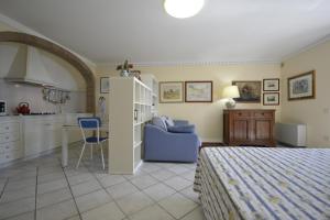 a bedroom with a bed and a table and a kitchen at Appartamento Valentina in Cortona