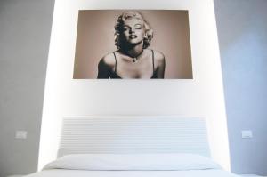 代森扎诺-德尔加达Maison Audrey的一张床上墙上的女人的照片