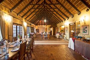 a dining room with tables and chairs in a building at Wild Rose Country Lodge in Noordhoek