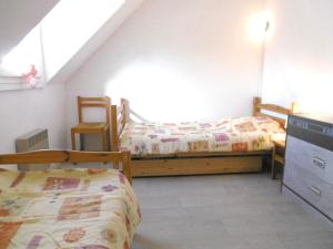 サルゾーにあるMaisonnette Kristellのベッドルーム1室(ベッド2台、テーブル、椅子付)