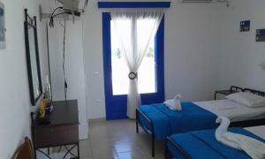a bedroom with two beds and a window at Vigles in Adamantas