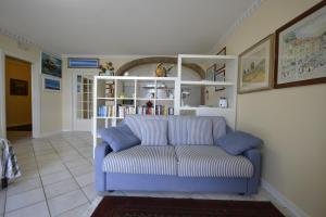a living room with a blue couch and a book shelf at Appartamento Valentina in Cortona