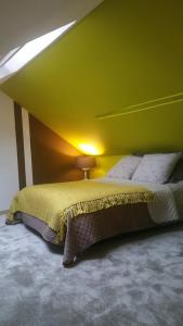Selvigny的住宿－51 côté jardin，一间卧室配有一张带绿色墙壁的床