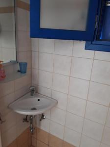 a white sink in a bathroom with a blue window at Vigles in Adamantas