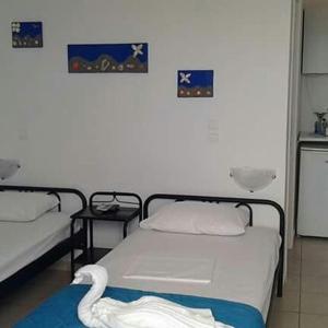 a room with two beds and two pictures on the wall at Vigles in Adamantas