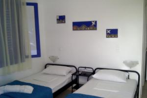 two beds in a room with pictures on the wall at Vigles in Adamantas