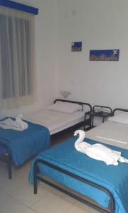 a hospital room with three beds with swans on them at Vigles in Adamantas