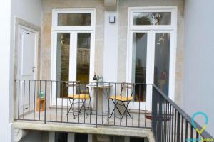 einen Balkon mit 2 Stühlen und einem Tisch in der Unterkunft Lovely Porto in Porto