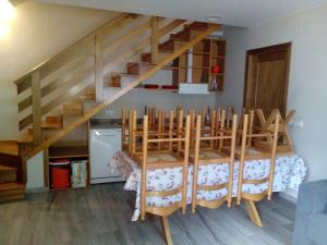 a room with a staircase with chairs and a table at Casa Rural Las Mestas in Cangas del Narcea