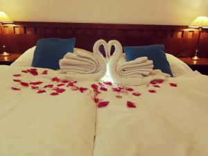 two white swans sitting on top of a bed with roses at Retro Hotel Villa Ostrava in Ostrava