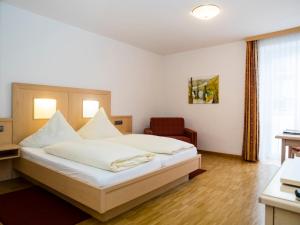 a hotel room with a bed and a chair at Weingutshotel Piesporter Goldtröpfchen in Piesport