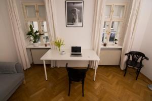 ウィーンにあるVienna Premium Room Naschmarkt IIのリビングルーム(ノートパソコン付きの白いテーブル付)