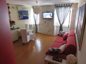 a living room with a red couch and a table at Apartment Sunrise in Korčula