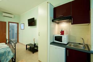 una piccola cucina con lavello e microonde di B&B La Porta a Roma