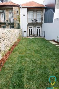 un patio frente a una casa con una pared de piedra en Lovely Porto, en Oporto