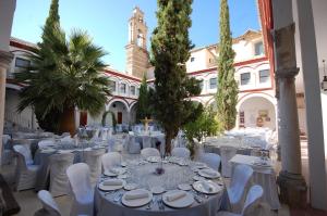 un salón de banquetes con mesas blancas y sillas blancas en Hotel Hospederia San Francisco, en Priego de Córdoba