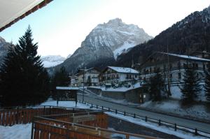 a village in the mountains with snow on the ground at IHR Hotel Villa Emma in Canazei