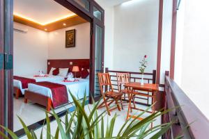 a hotel room with a bed and a table and chairs at Gia Phát Homestay in Hoi An