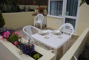 a white table and chairs on a patio with flowers at Ashbury Tor in Torquay