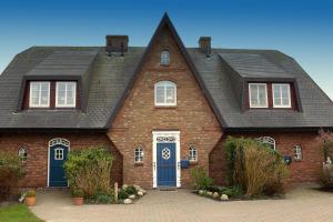 a large red brick house with a black roof at Ferienhaus Weetstich in Archsum