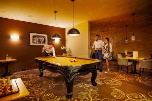 a group of people in a room with a pool table at Don Giovanni Hotel Prague - Great Hotels of The World in Prague
