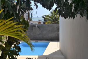 a swimming pool next to a white wall with a view of the ocean at 21LG Le Morne View in La Gaulette