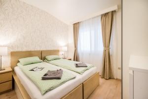 ein Schlafzimmer mit einem großen Bett mit grüner Bettwäsche in der Unterkunft The Lion's Loft Apartment - 4BR & 3BA - Terrace - AC in Budapest