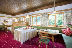 a dining room with tables and chairs and windows at Hotel-Pension Faneskla in Silbertal