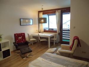 een kamer met een bed en een tafel en stoelen bij Garconniere Pachler in Gosau
