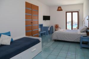 una camera con due letti e una tv di Hotel Torre Sant'Angelo a Ischia