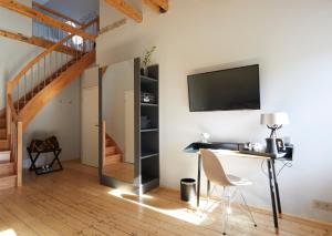 a living room with a desk and a tv on a wall at LIONO BoutiqueHotel in Goslar